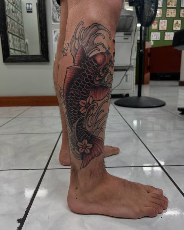 Koi fish tattoo in Japanese style on a person's calf.