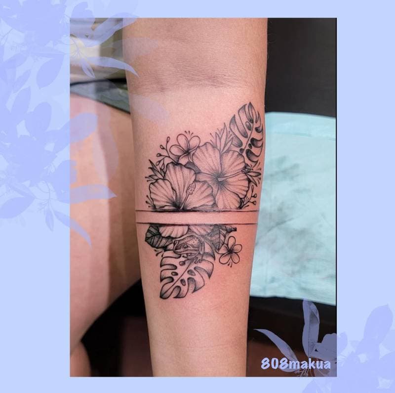 Black and grey floral tattoo on a forearm.