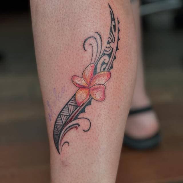 Tribal and flower tattoo on the calf.
