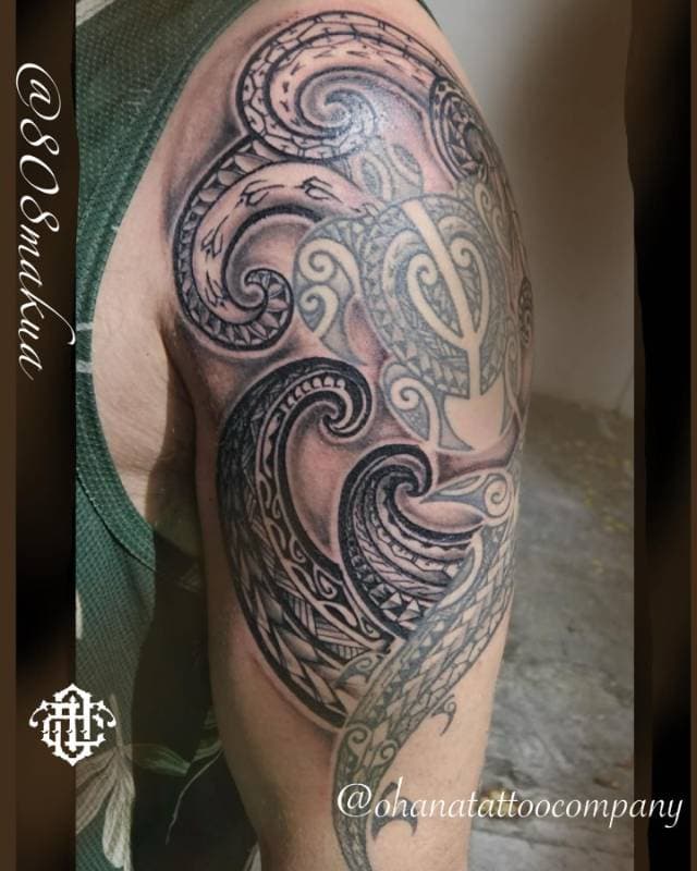 Black and grey tribal tattoo on a person's upper arm.